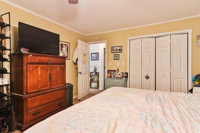 bedroom featuring a textured ceiling, a closet, and ornamental molding