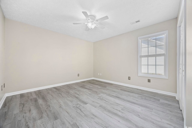 spare room with a textured ceiling, light hardwood / wood-style floors, and ceiling fan