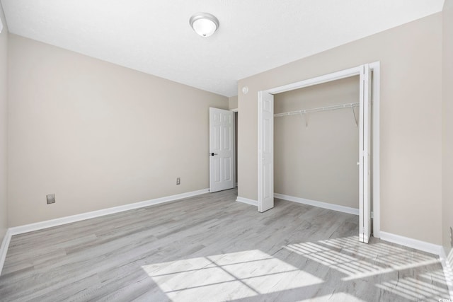 unfurnished bedroom featuring light hardwood / wood-style floors and a closet