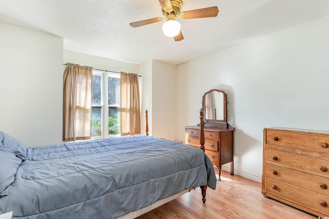 bedroom featuring a textured ceiling, light hardwood / wood-style floors, and ceiling fan