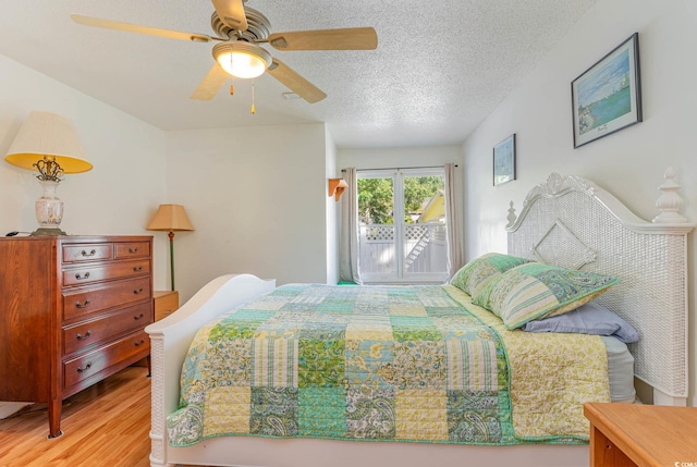 bedroom with a textured ceiling, wood-type flooring, and ceiling fan