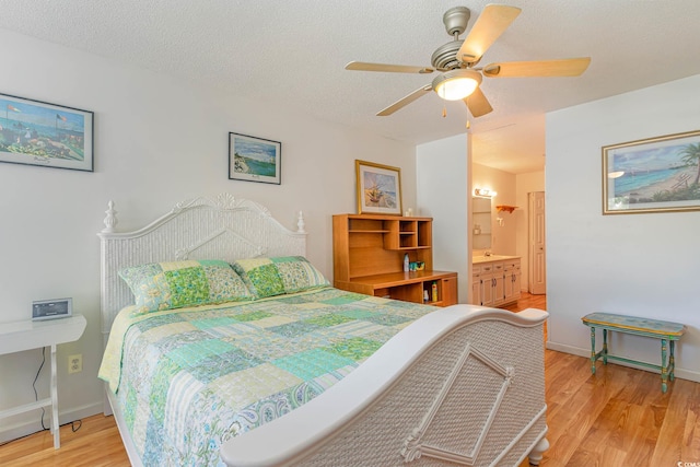 bedroom featuring a textured ceiling, connected bathroom, light wood-type flooring, and ceiling fan