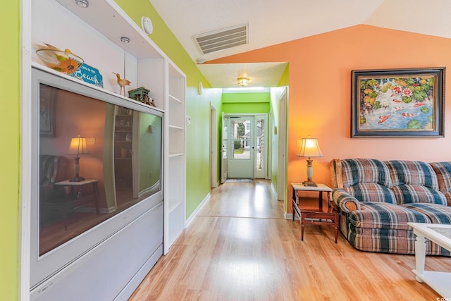 hall featuring lofted ceiling and light hardwood / wood-style flooring