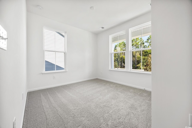 carpeted empty room featuring baseboards