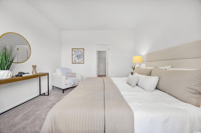 carpeted bedroom featuring a closet and a spacious closet