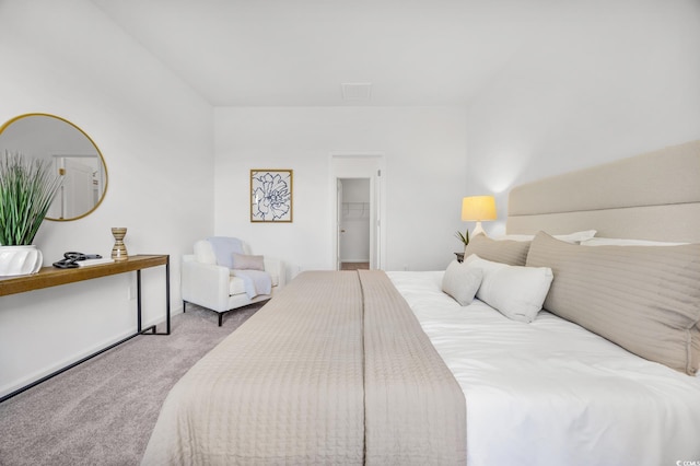 bedroom featuring a walk in closet, visible vents, and carpet