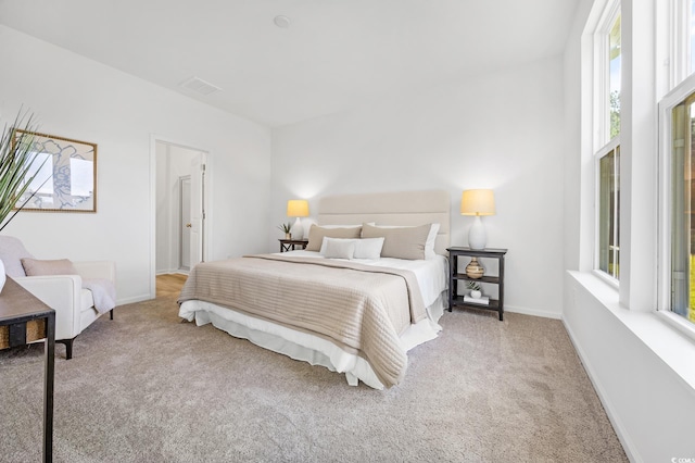 carpeted bedroom with baseboards and multiple windows