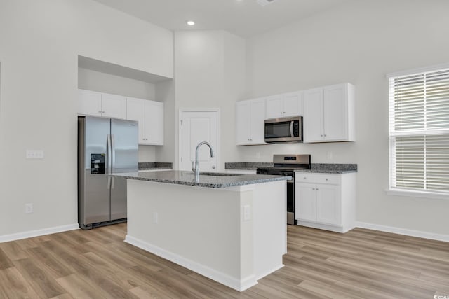 389 Sun Colony Blvd, Longs, SC 29568 - kitchen with stainless steel appliances, a high ceiling, light wood finished floors, white cabinets, and recessed lighting