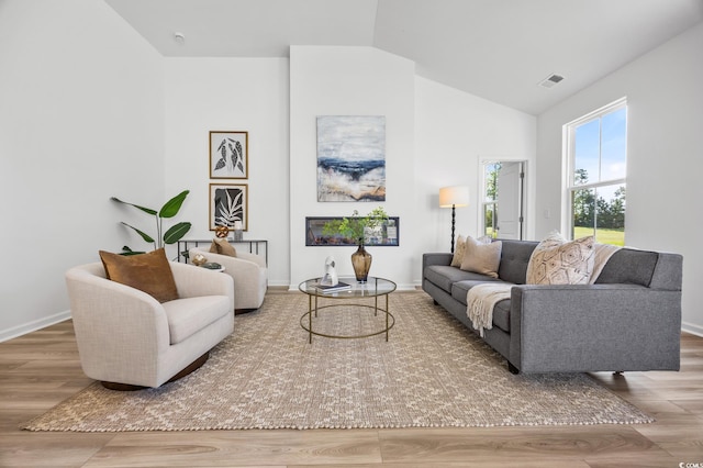 living room featuring lofted ceiling and hardwood / wood-style floors