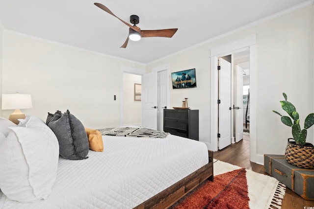 bedroom with crown molding, dark wood-type flooring, and ceiling fan