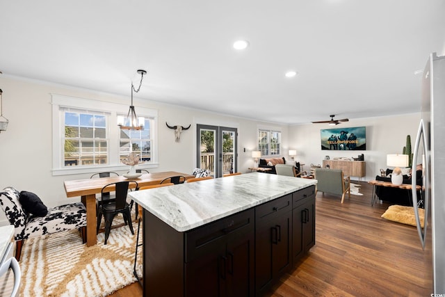 kitchen featuring a kitchen island, hanging light fixtures, dark hardwood / wood-style floors, and a healthy amount of sunlight