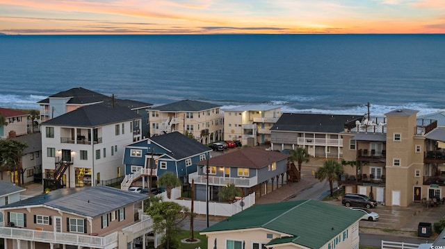 aerial view at dusk featuring a water view