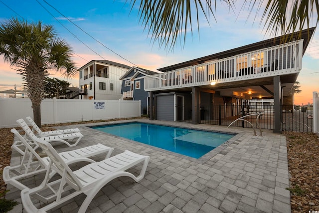 pool at dusk featuring a patio area