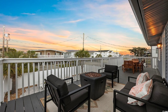 deck at dusk with an outdoor living space with a fire pit