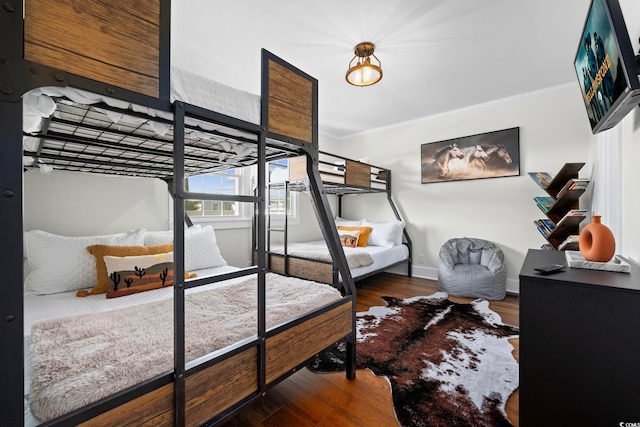 bedroom with dark wood-type flooring and crown molding