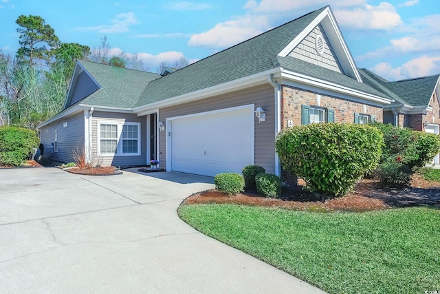 view of front of property with driveway, a garage, a shingled roof, a front lawn, and brick siding