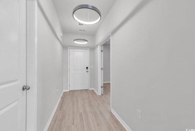 hallway with light hardwood / wood-style flooring