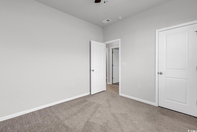 unfurnished bedroom featuring light colored carpet and ceiling fan