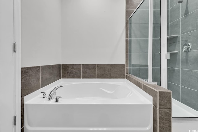 bathroom featuring shower with separate bathtub