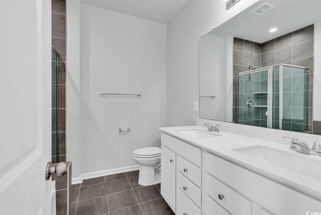 bathroom featuring vanity, toilet, tile patterned floors, and a shower with shower door