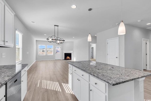 kitchen featuring hanging light fixtures, white cabinetry, dishwasher, and a center island