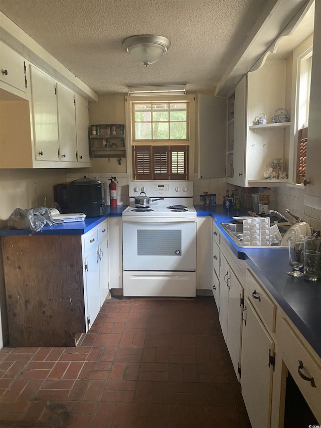 kitchen with decorative backsplash, electric range, white cabinets, and a textured ceiling