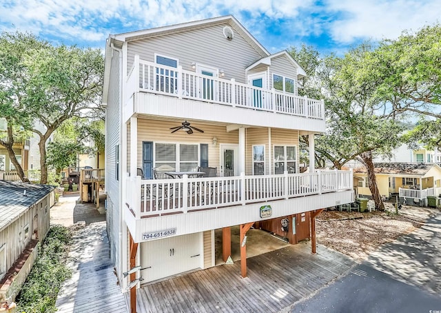 back of property with a balcony, a wooden deck, and ceiling fan