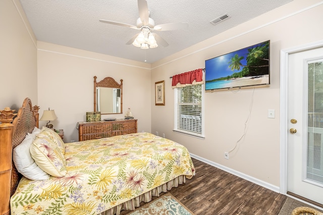 bedroom featuring hardwood / wood-style floors, multiple windows, a textured ceiling, and ceiling fan