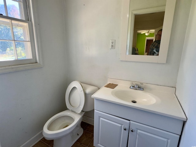 bathroom featuring vanity, toilet, tile patterned floors, and ceiling fan