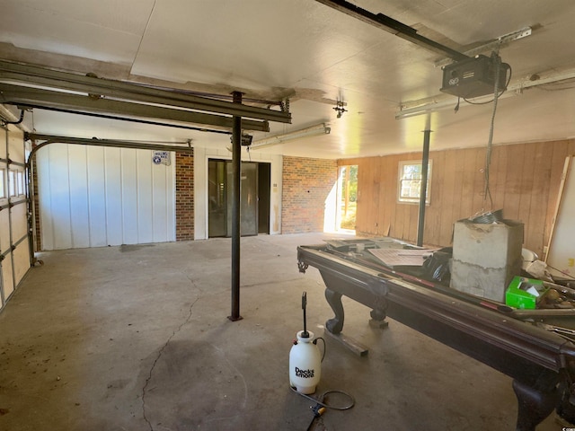 garage featuring a garage door opener and wood walls