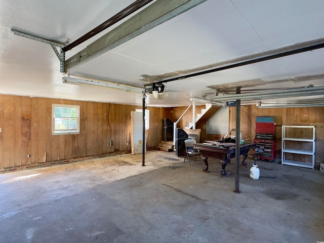 garage featuring a garage door opener and wooden walls