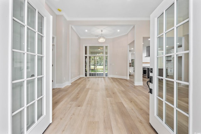 interior space with french doors, ornamental molding, and light wood-type flooring