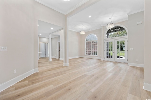 unfurnished living room featuring french doors, light hardwood / wood-style floors, and ornamental molding