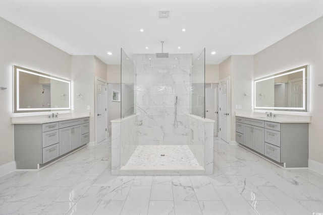 bathroom with a tile shower and vanity