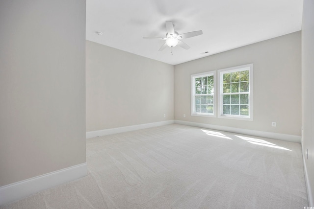 unfurnished room with light colored carpet and ceiling fan