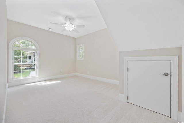 interior space with light carpet, lofted ceiling, and ceiling fan