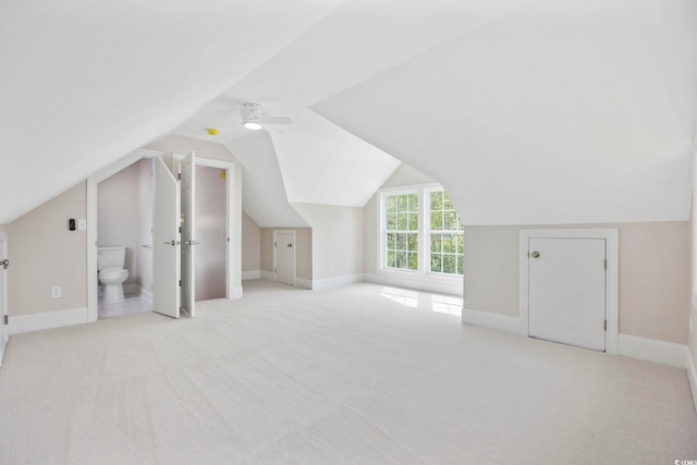 additional living space with ceiling fan, vaulted ceiling, and light colored carpet