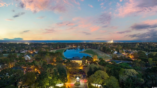 aerial view at dusk featuring a water view