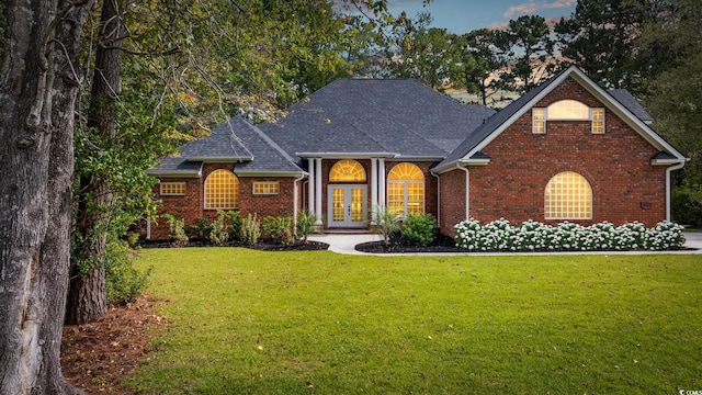 view of front of property featuring french doors and a front lawn