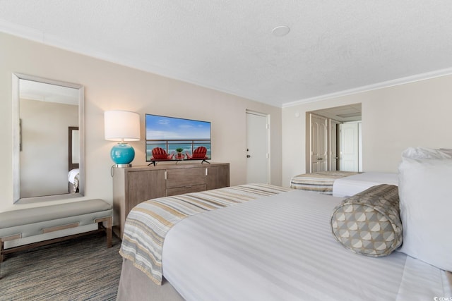 bedroom featuring ornamental molding, a textured ceiling, and carpet