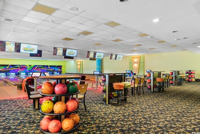 game room with carpet flooring, a drop ceiling, and bowling