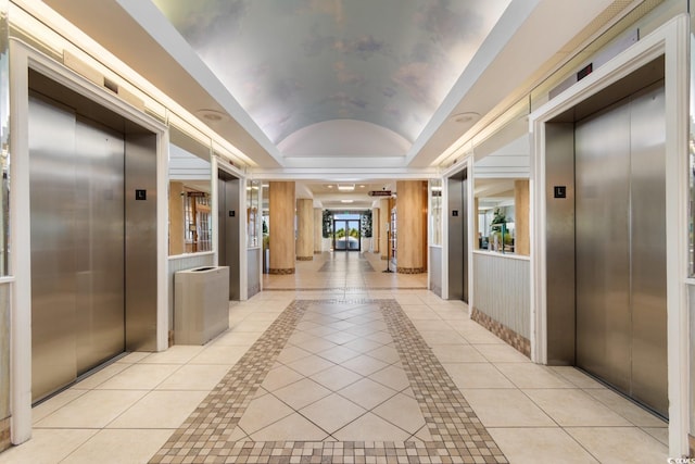 hall featuring lofted ceiling, light tile patterned flooring, and elevator