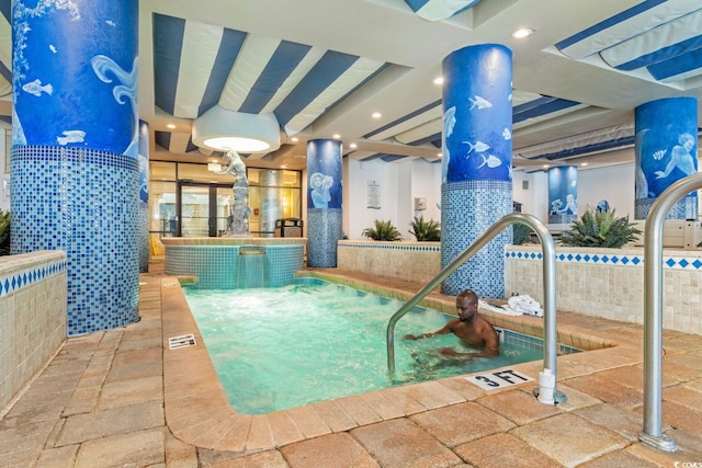 view of swimming pool with an indoor hot tub