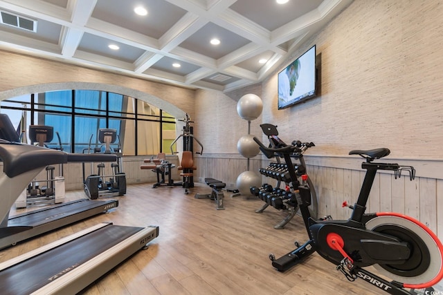 gym with coffered ceiling, hardwood / wood-style flooring, and wood walls