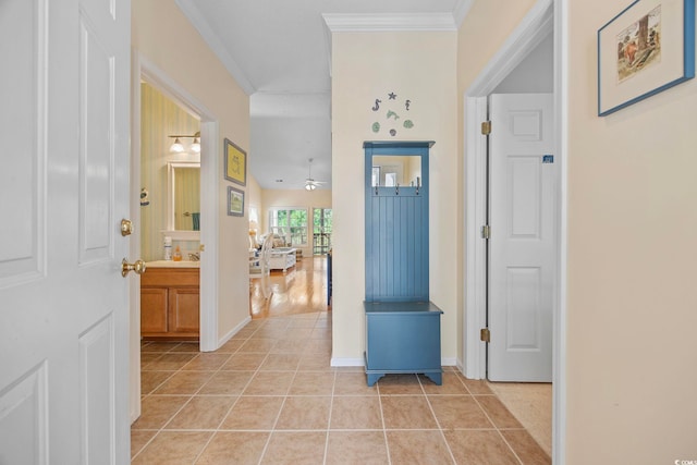 foyer with light tile patterned floors, crown molding, and ceiling fan