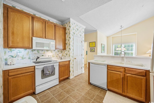 kitchen with pendant lighting, sink, white appliances, and a textured ceiling