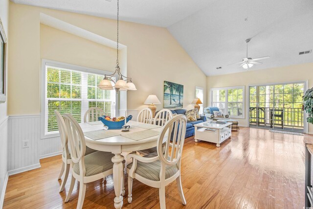 dining space with plenty of natural light, high vaulted ceiling, ceiling fan, and light wood-type flooring