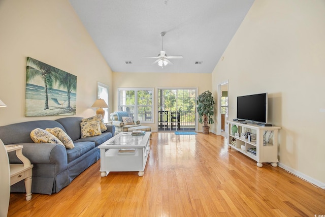 living room featuring light hardwood / wood-style flooring, high vaulted ceiling, and ceiling fan