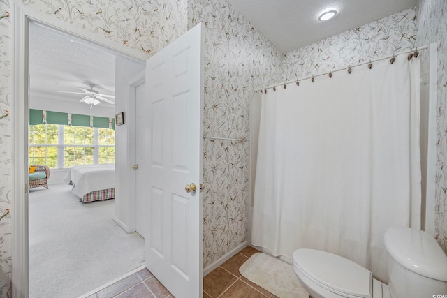 bathroom featuring tile patterned flooring, ceiling fan, a textured ceiling, and toilet