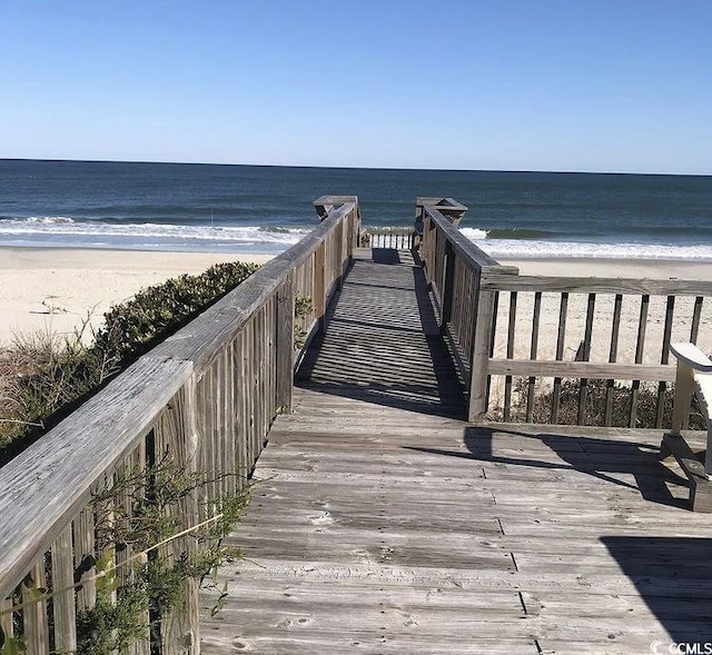 view of home's community with a water view and a beach view